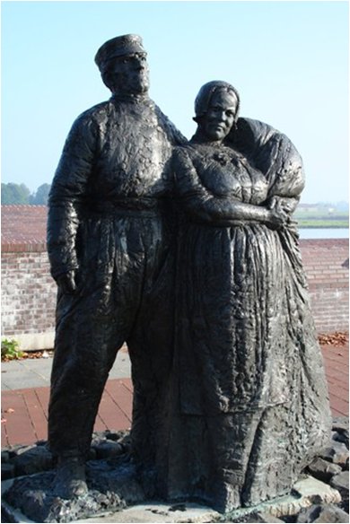 beeld door Norman Burkett van een Schokker echtpaar, uitgevoerd in brons met een hoogte van 1.70 meter